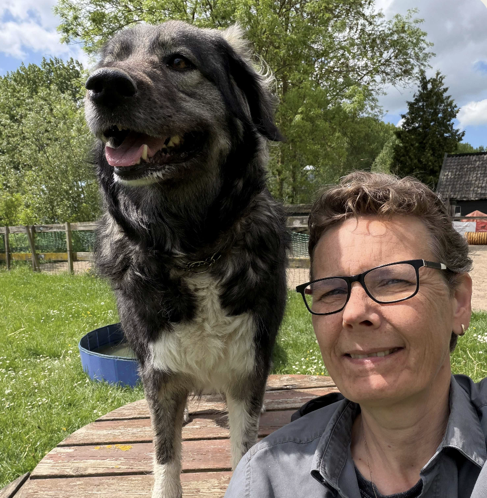 Nicole Rowaan van A Doggy Business met een hond in een groen veld