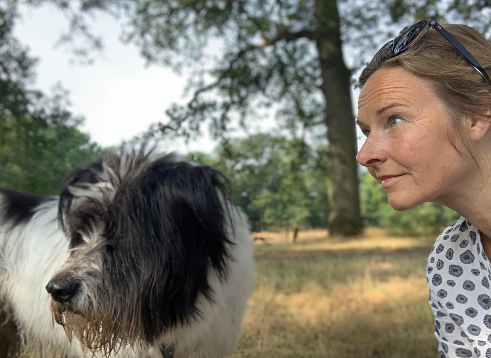 Geneviève kijkt een hond oog in oog aan tijdens een wandeling in de natuur